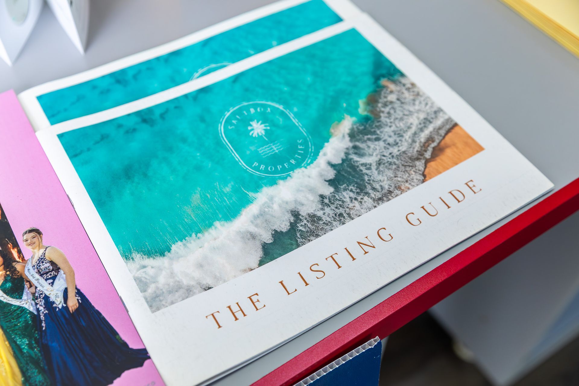 The Listing Guide booklet with a beach photo on the cover. White and gold text on a white background.