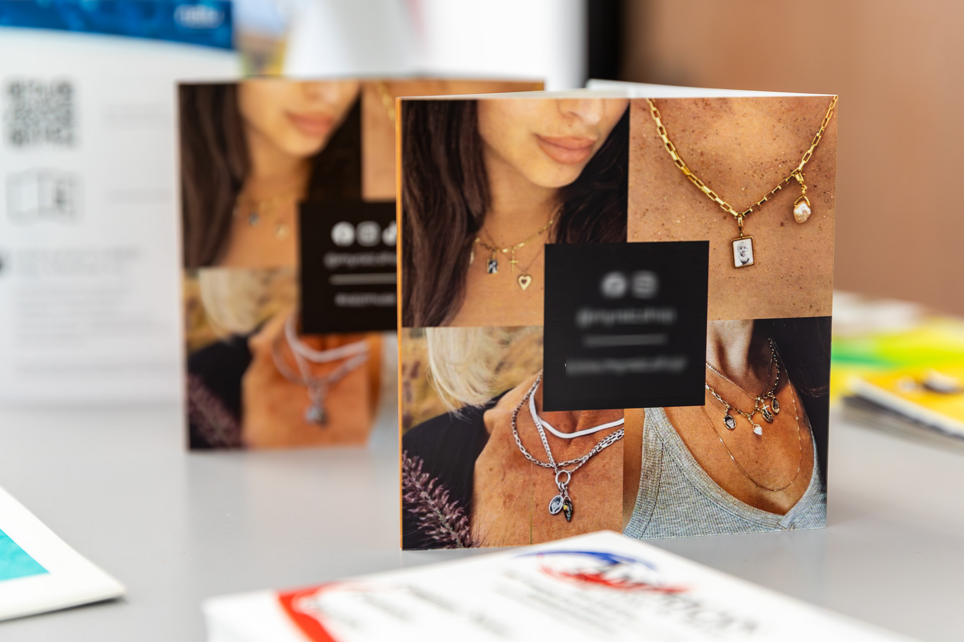 Jewelry cards displaying necklaces, with a woman's neck and chest featured in collaged images. A business logo is present.