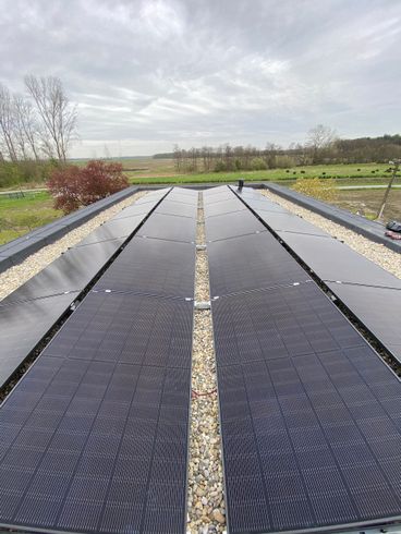 Een rij zonnepanelen op het dak van een gebouw.