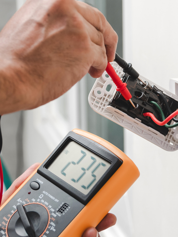 Iemand gebruikt een multimeter om een ​​stopcontact te testen
