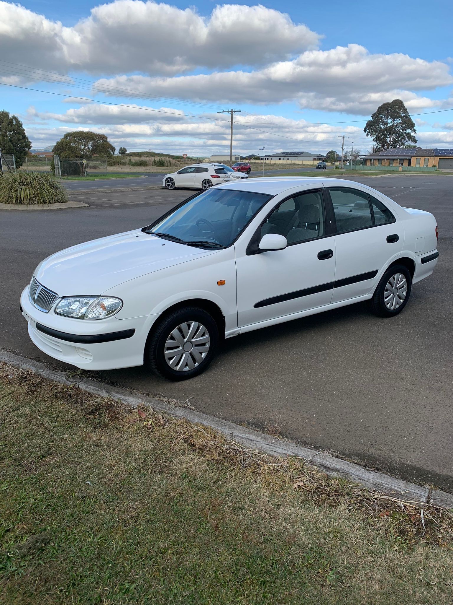A white car is parked in a parking lot.