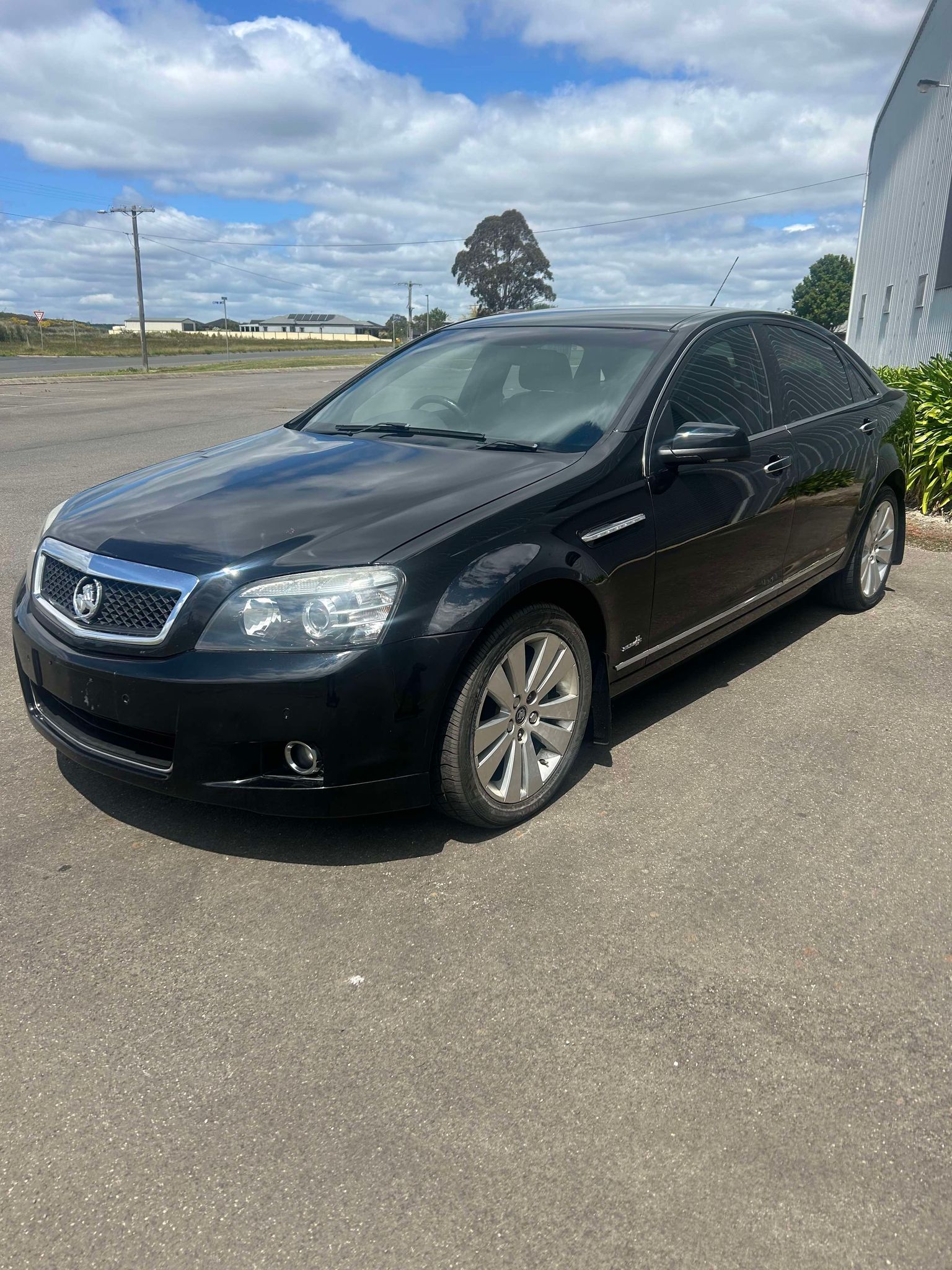A black car is parked in a parking lot.