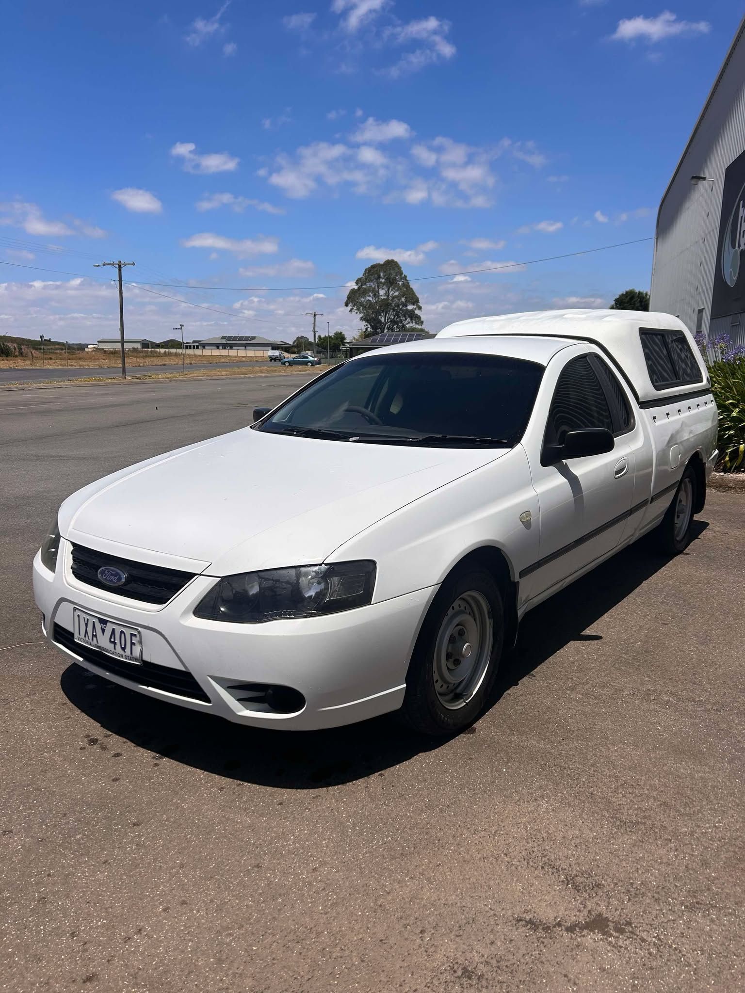 A white pickup truck is parked in a parking lot.
