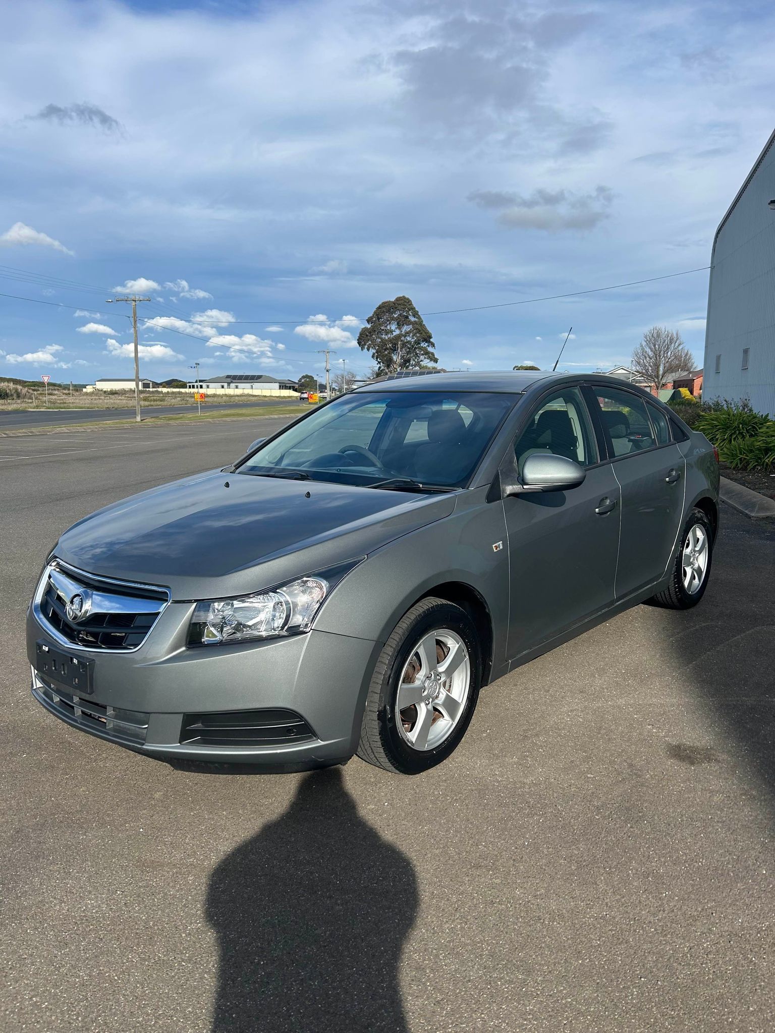 A gray car is parked in a parking lot.