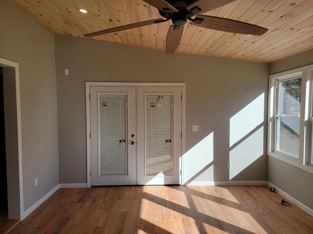 A living room with hardwood floors and a ceiling fan.