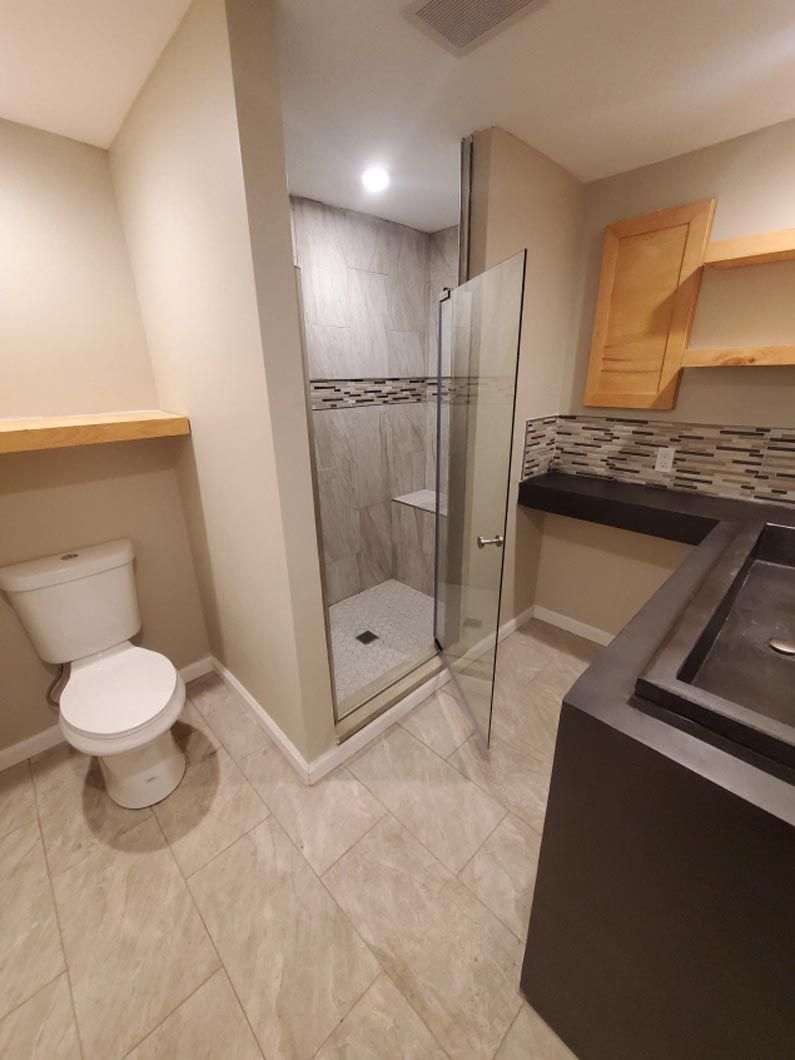 A bathroom with a toilet and a walk in shower