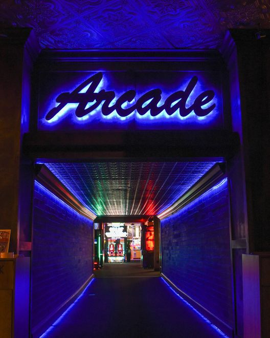 A neon sign that says tacos is lit up on a brick wall.