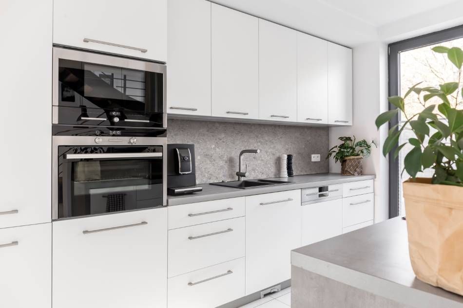 Een keuken met witte kasten en roestvrijstalen apparatuur.