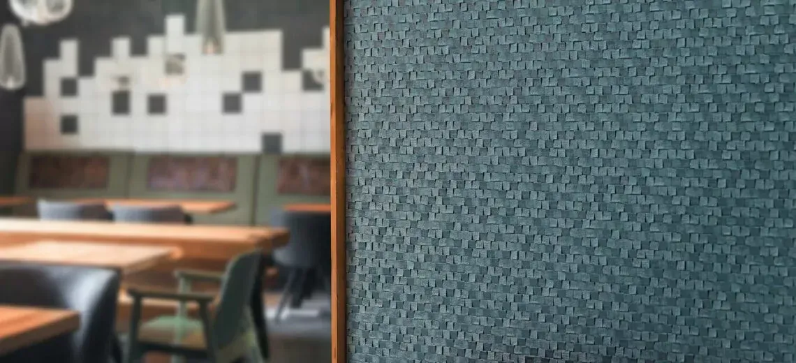 Een wazige foto van een restaurant met tafels en stoelen en een blauwe muur.