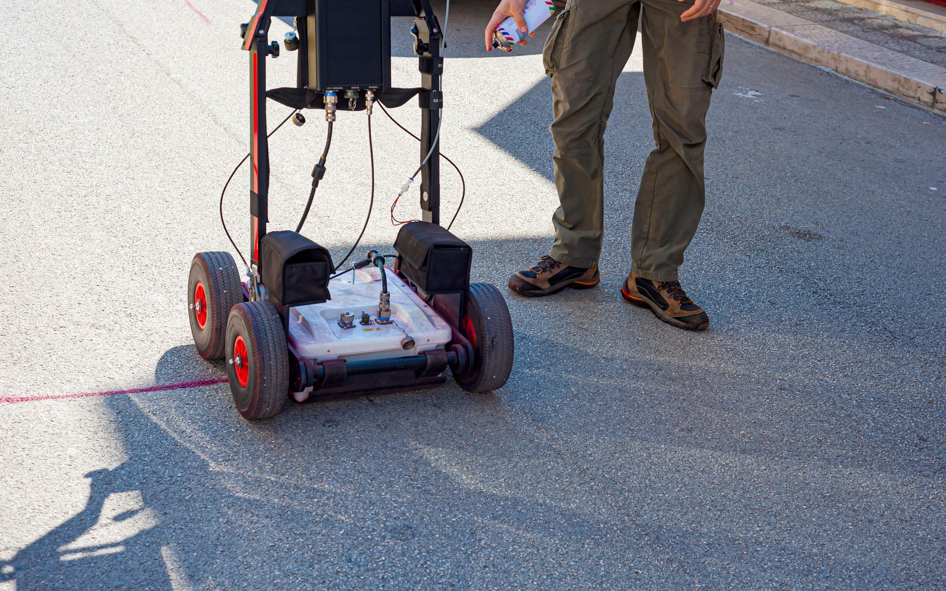 A man is standing next to a robot on the street.