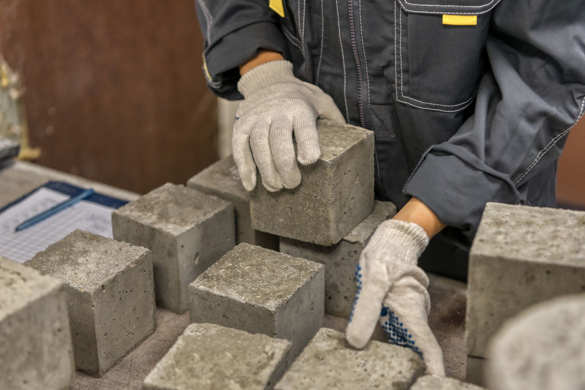 A person is stacking concrete blocks on top of each other on a table.