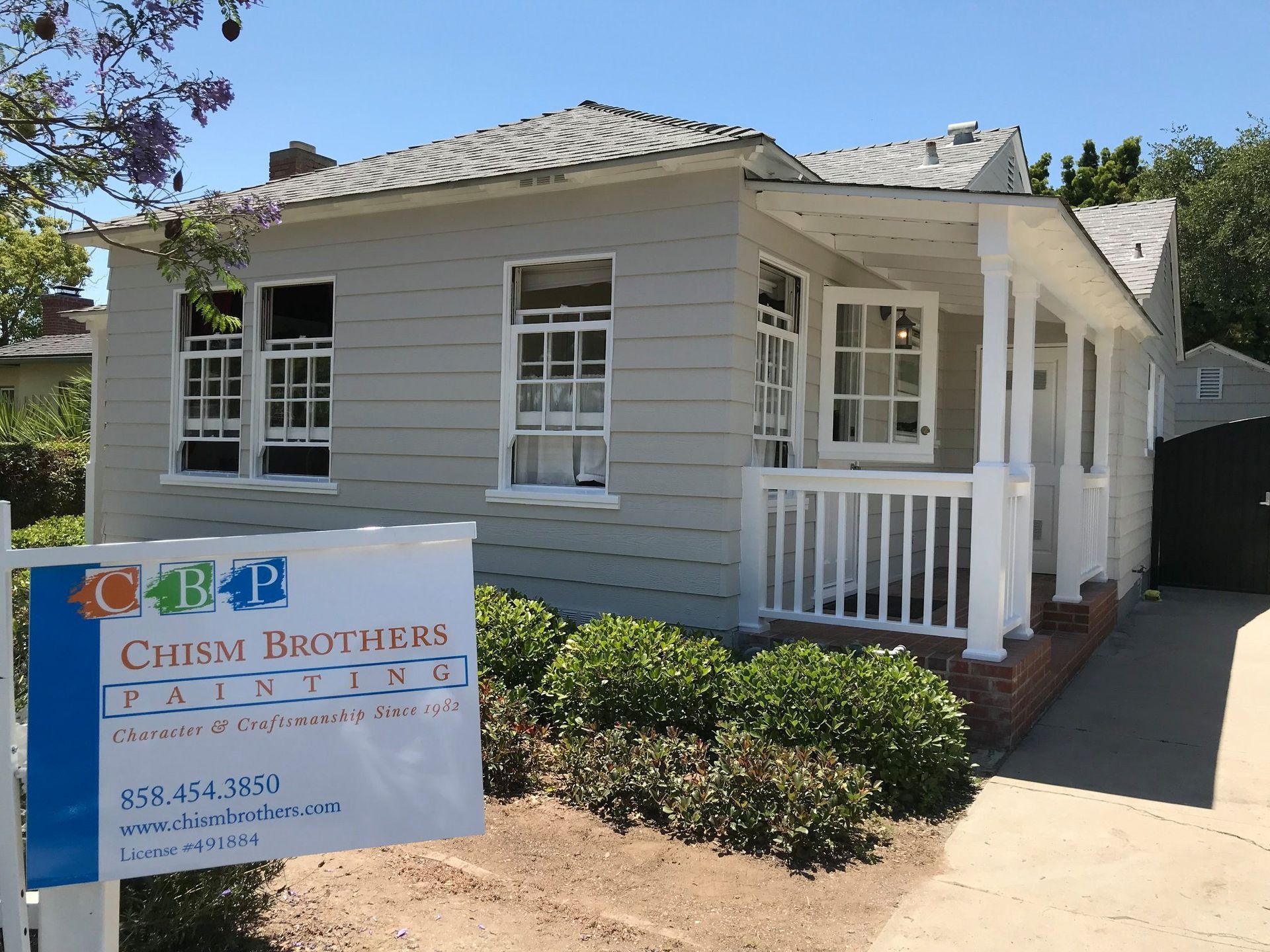 House painted light gray with white trim, sign in front: Chism Brothers Painting.