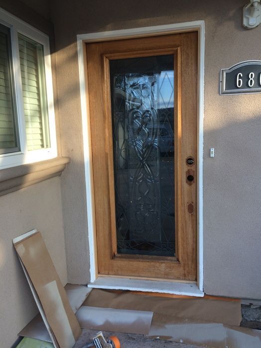 Wooden front door with glass panel, white trim, and a house number 680 on the side.