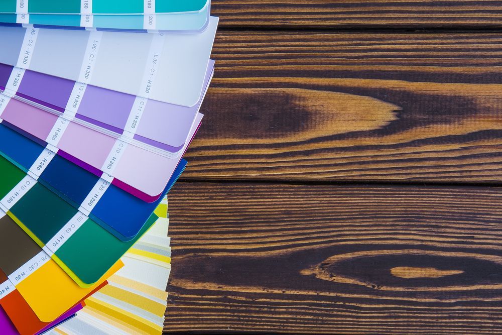 Color swatches on wood grain surface, various colors, for design or paint selection.