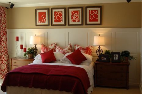 Bedroom with red and white decor; bed, artwork, lamps, and chests.