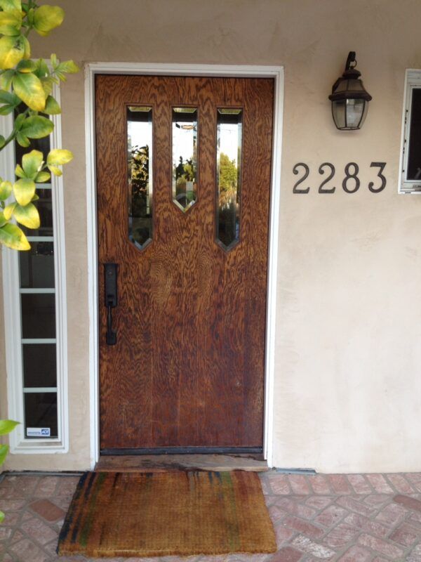 Wooden front door with three glass panels, house number 