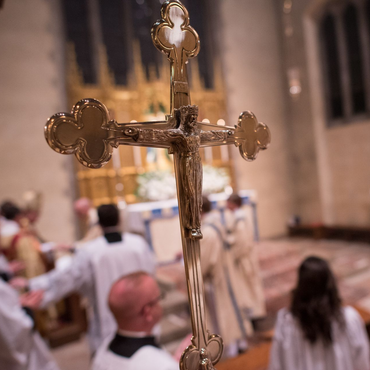 A religious procession with altar servers carrying candles and incense at an altar, in church.