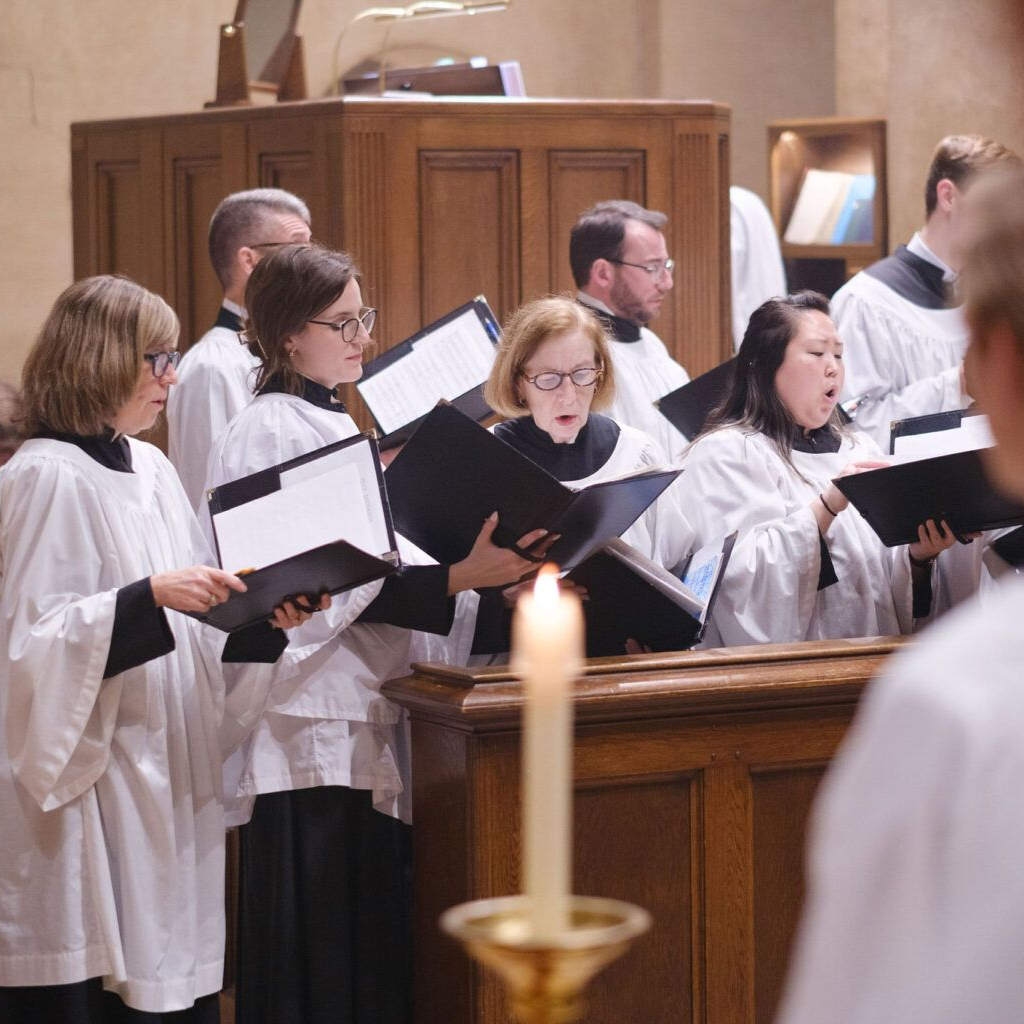 A religious procession with altar servers carrying candles and incense at an altar, in church.