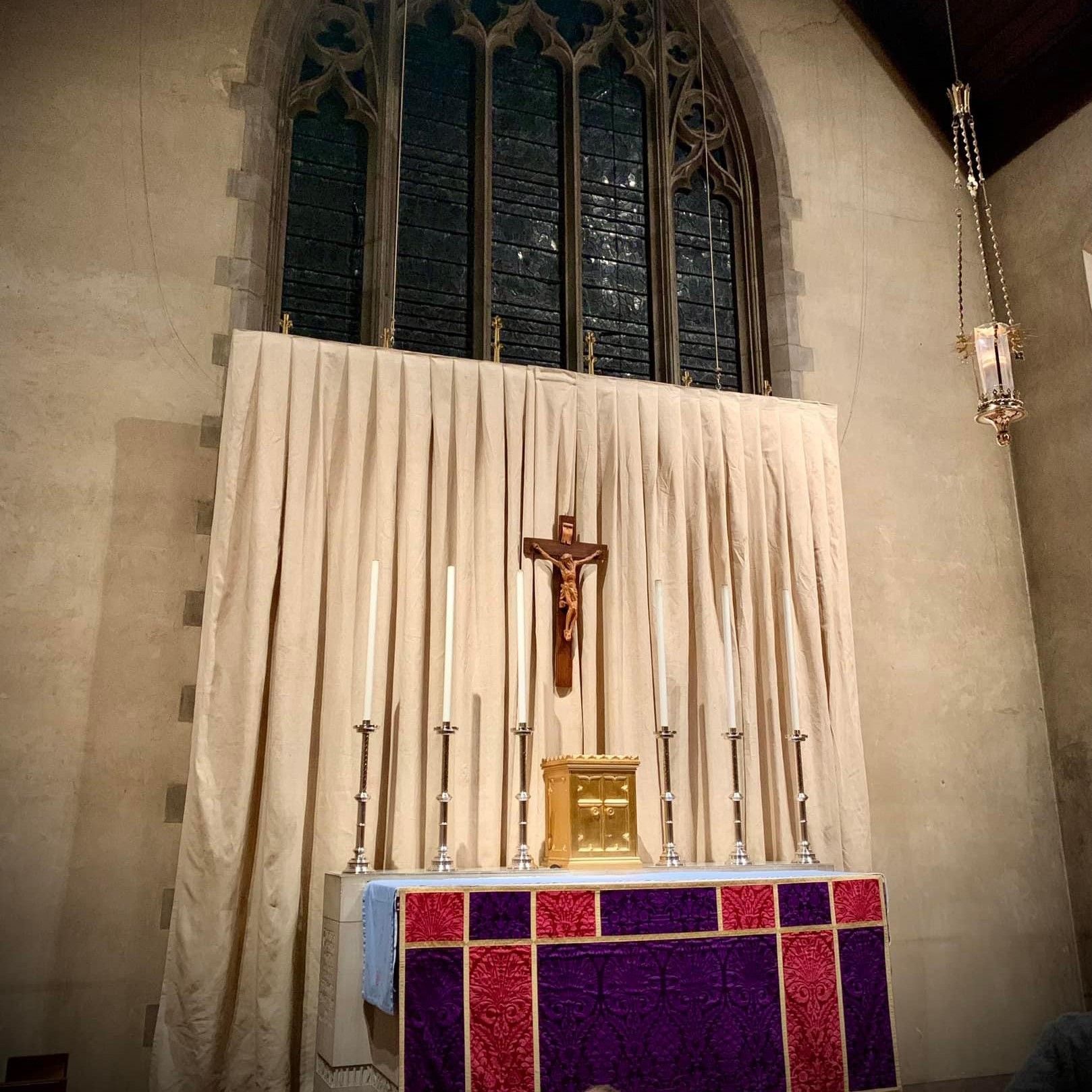 A religious procession with altar servers carrying candles and incense at an altar, in church.