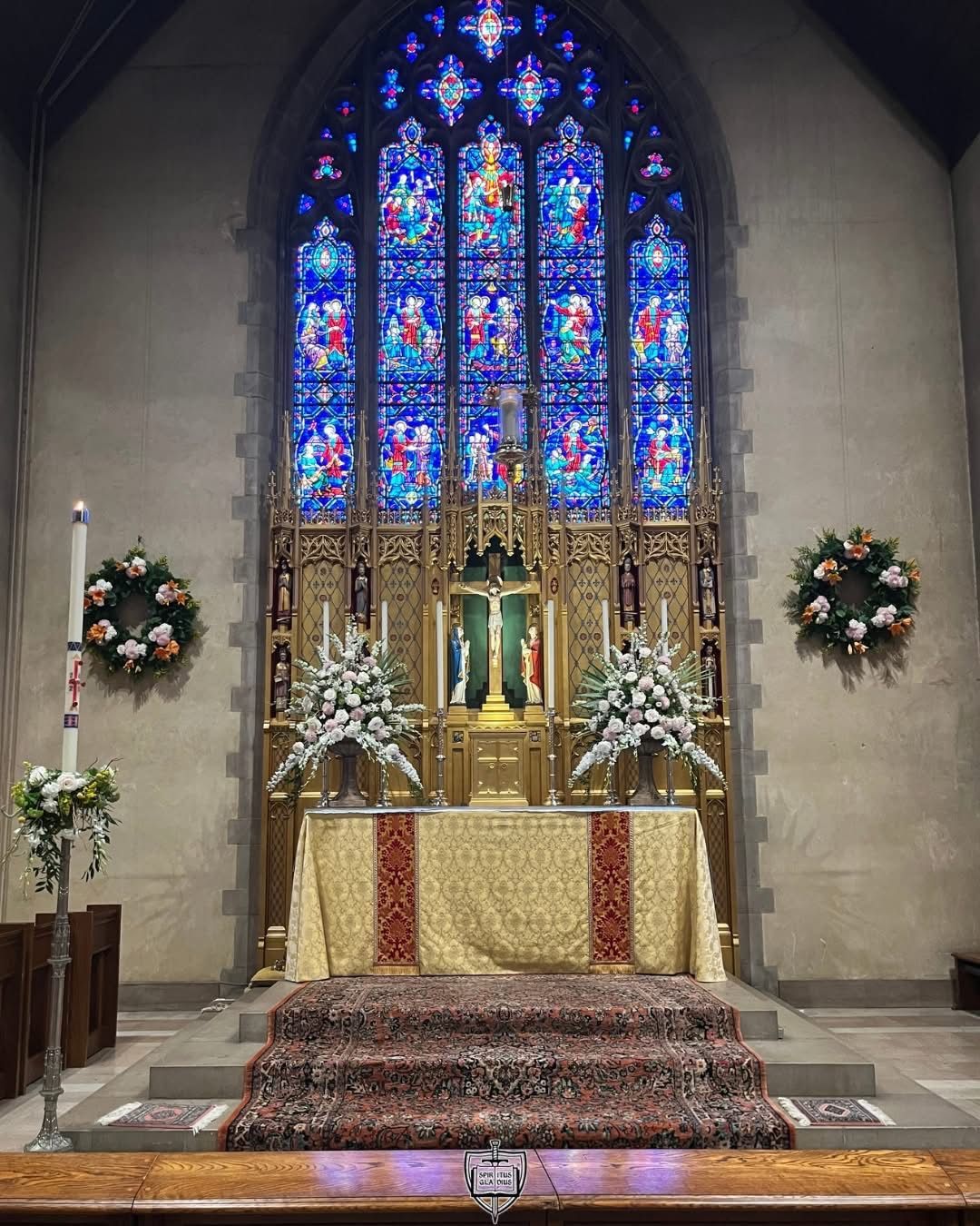 A religious procession with altar servers carrying candles and incense at an altar, in church.