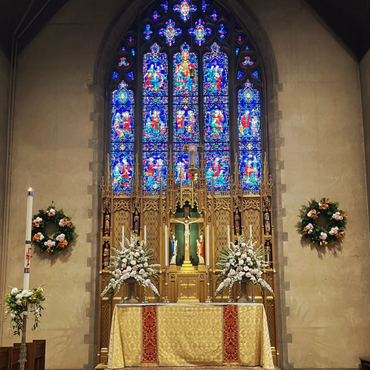 A religious procession with altar servers carrying candles and incense at an altar, in church.
