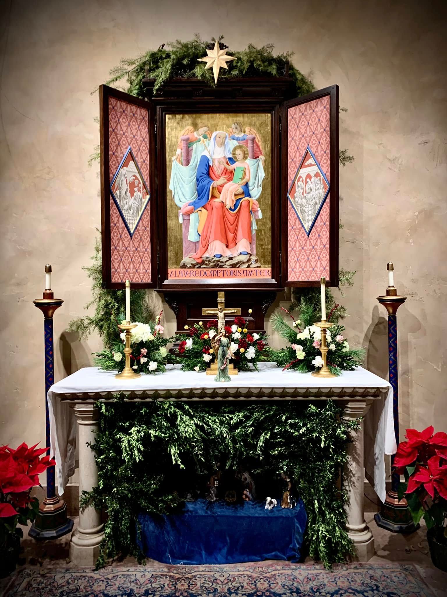 Choir singing in a dimly lit church holding candles, stained glass window.