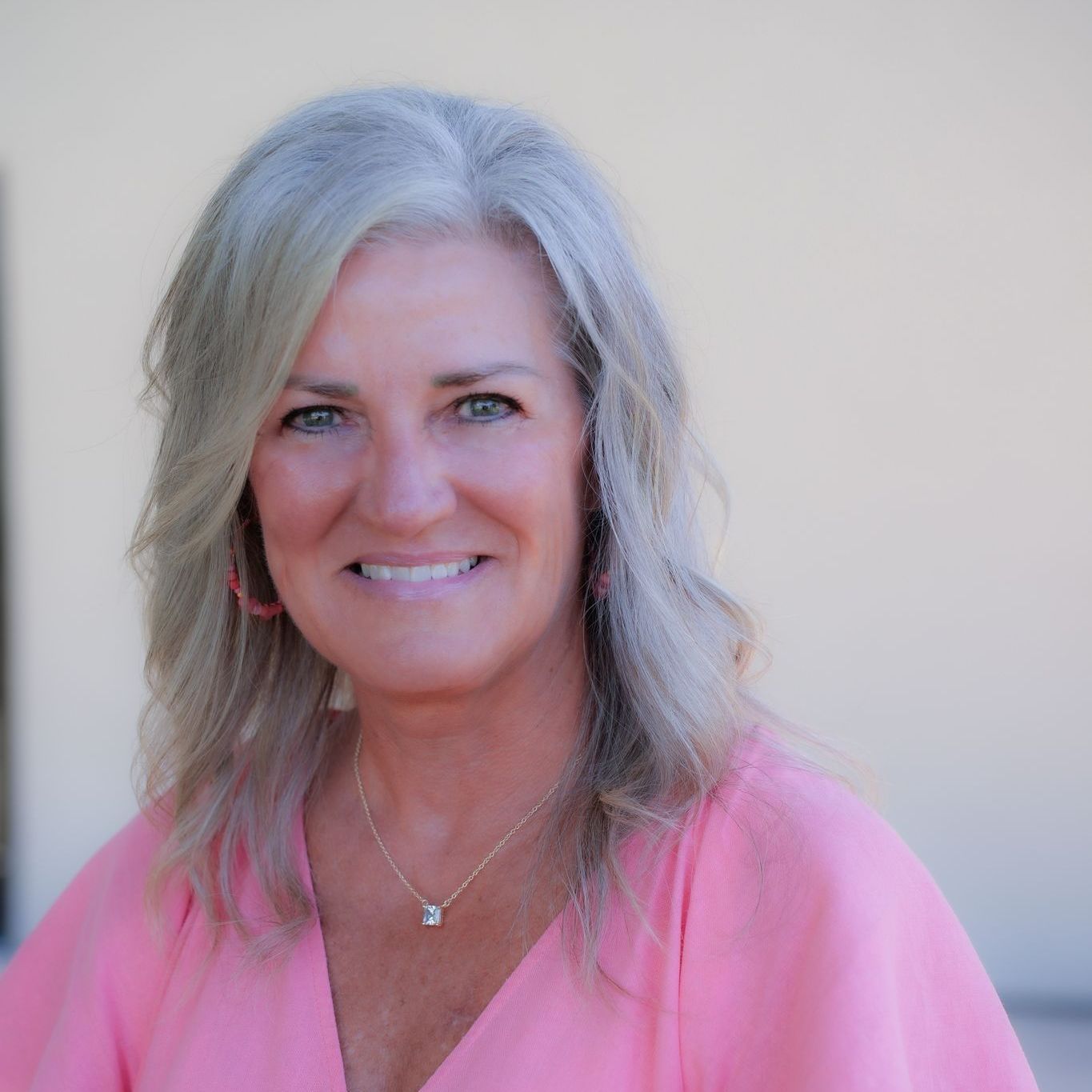 A man is holding a dog in his arms and the dog is wearing a sweater.