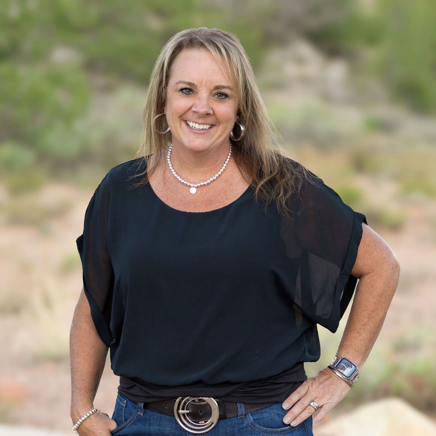 A man is holding a dog in his arms and the dog is wearing a sweater.