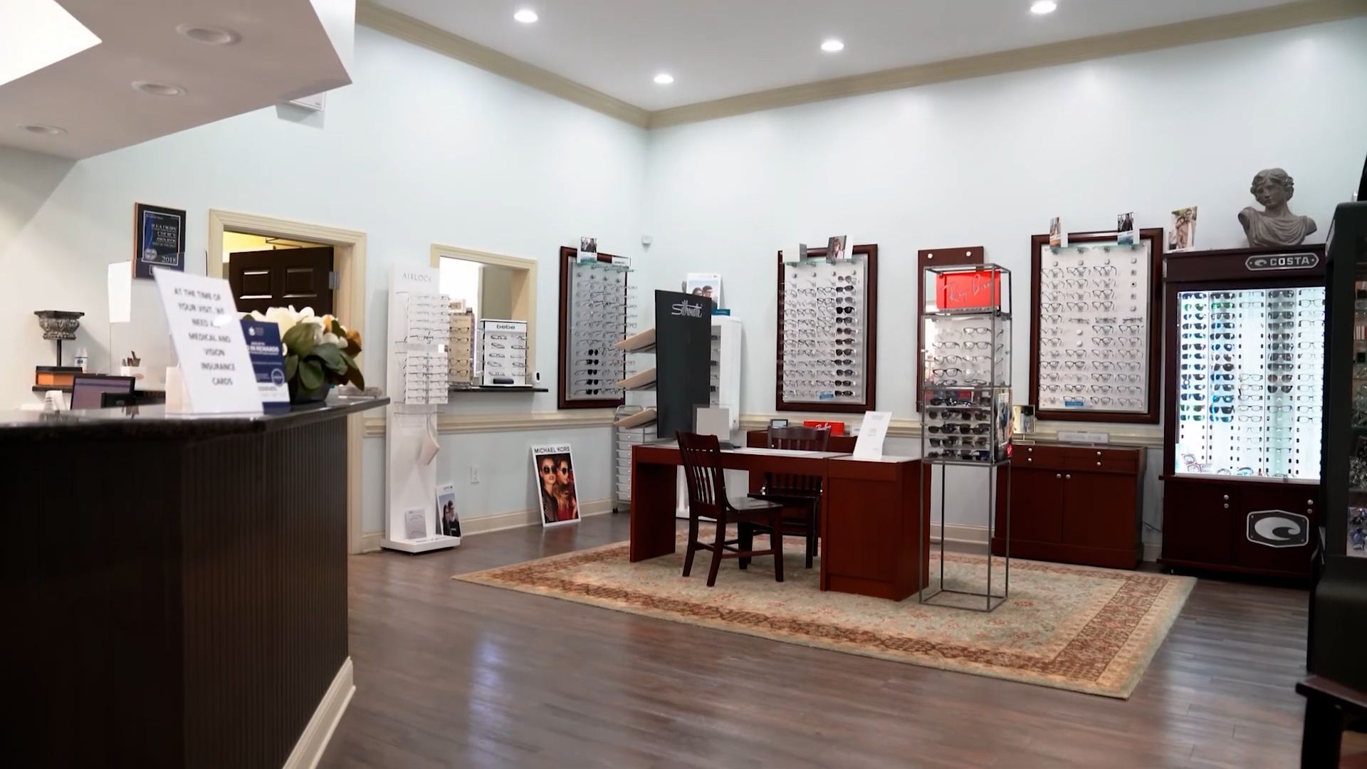 Eyewear store interior with display stands, desks, and rows of eyeglass frames on the walls in Hope Mills, NC.