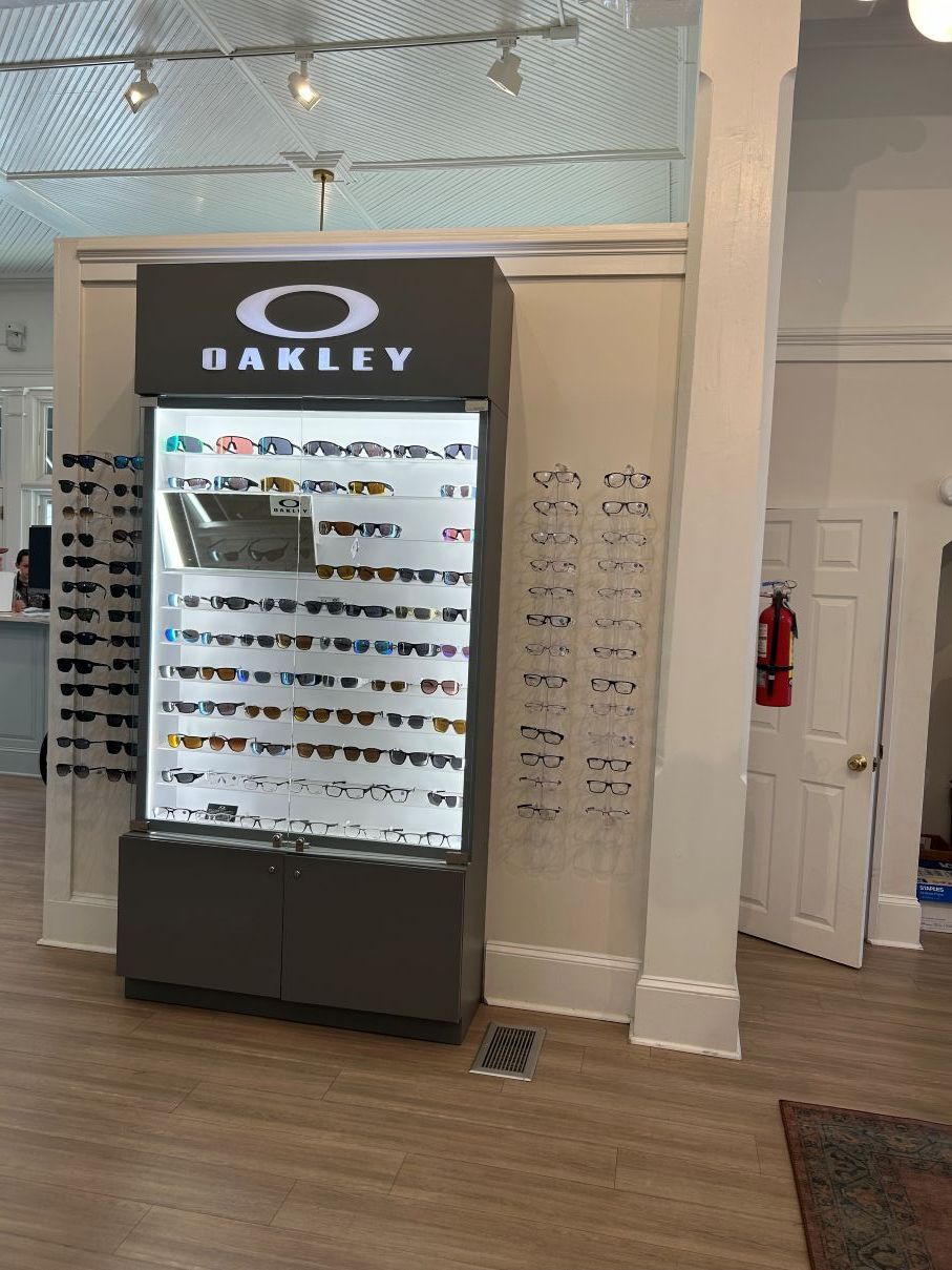 Oakley eyewear display cabinet in a bright retail store with rows of sunglasses in Hope Mills, NC.
