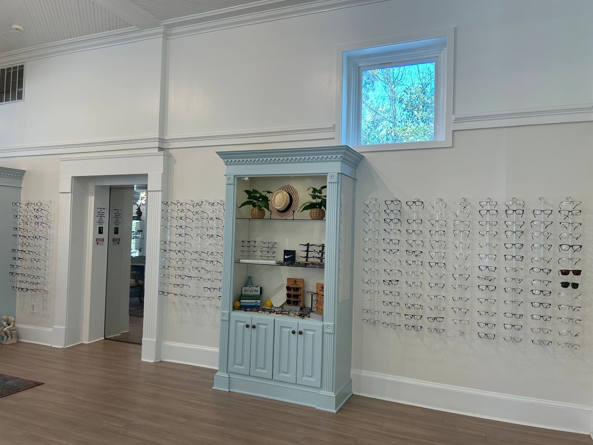 Bright white boutique interior with a blue display cabinet, wall decor, and wood flooring in Hope Mills, NC.