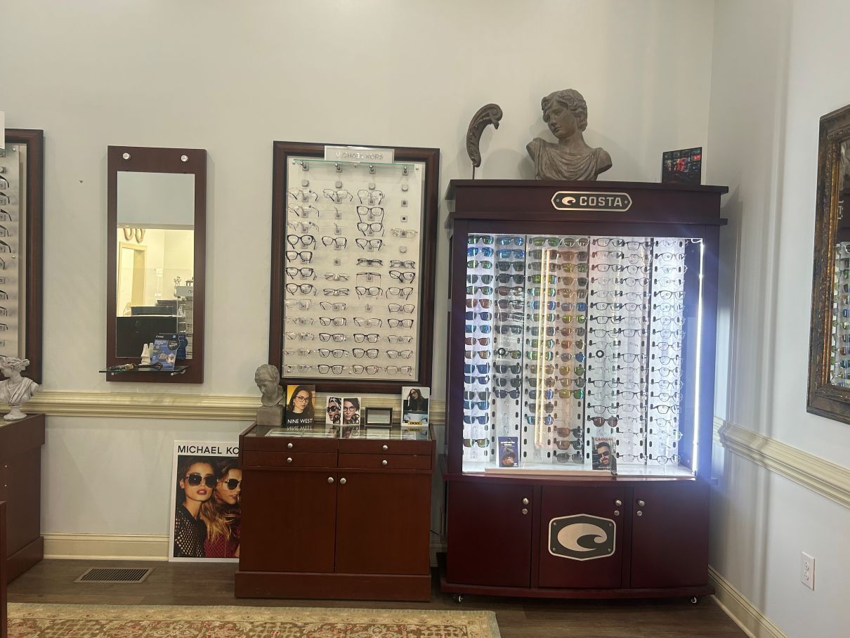Interior with posters, framed art, a bust sculpture, and a red sunglasses display cabinet in Eastover, NC.