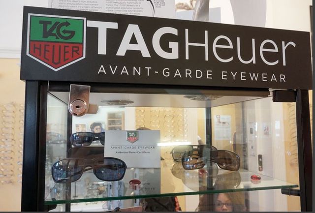 A glass display case featuring TAG Heuer branded sunglasses in an eyewear store.