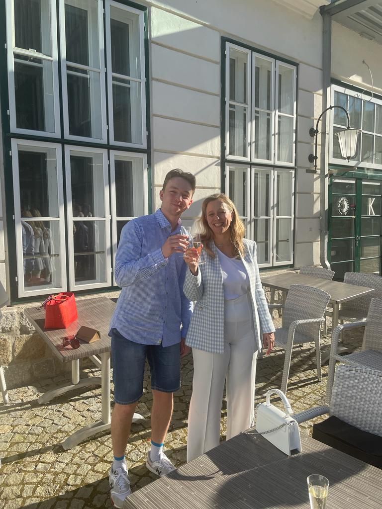 Ein Mann und eine Frau stehen vor einem Gebäude und trinken Champagner