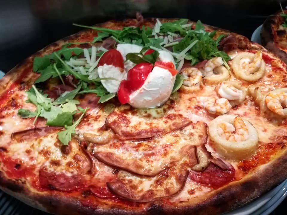 pizza con frutti di mare, rucola, grana e salame