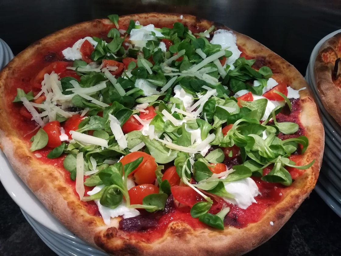 pizza con valeriana, pomodorini e scaglie di grana