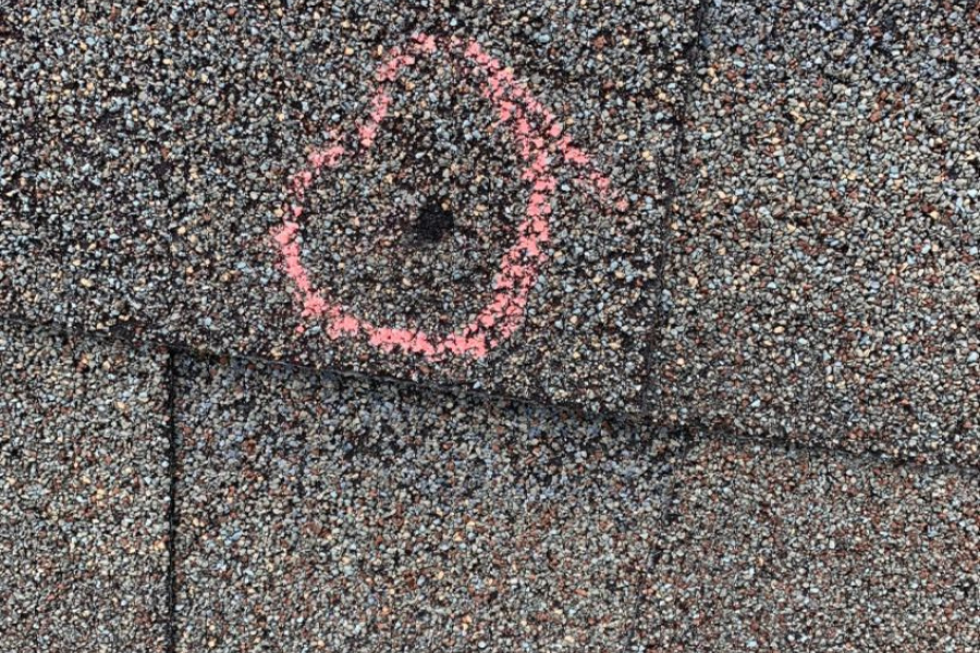 Close-up view of a roof puncture showing the damage that needs professional repair