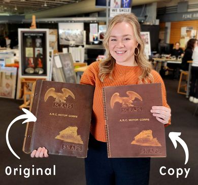 Woman in orange sweater holding two brown book covers labeled “Original” and “Copy” in a shop setting