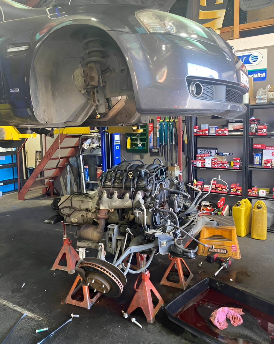 A car is hoisted above its engine in a mechanic garage — Jim Wall Automotive in Bowral, NSW