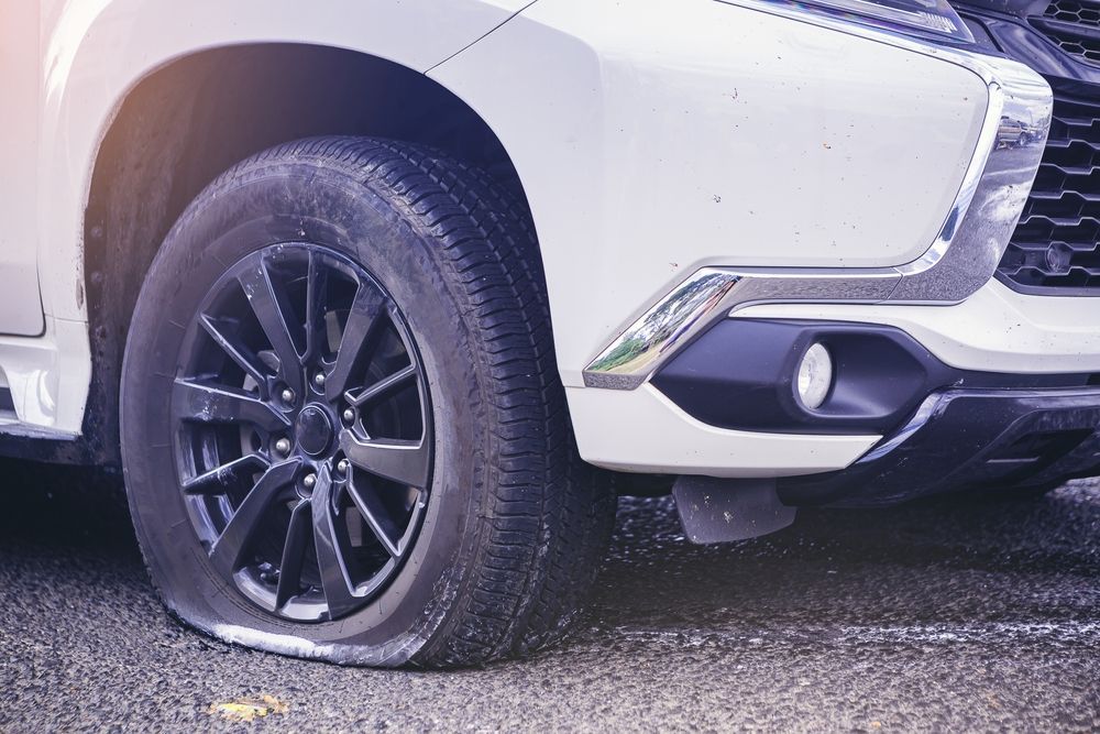 A white car with a flat tyre — Jim Wall Automotive in Mittagong, NSW