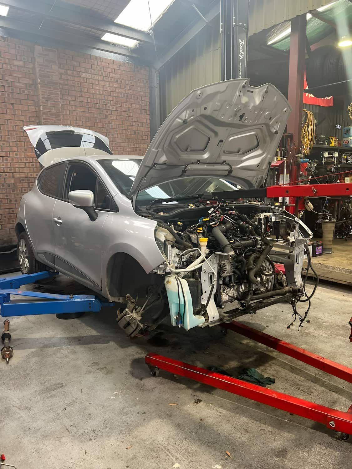 A Car With the Hood Open is Sitting on a Lift in a Garage β Jim Wall Automotive in Mittagong, NSW