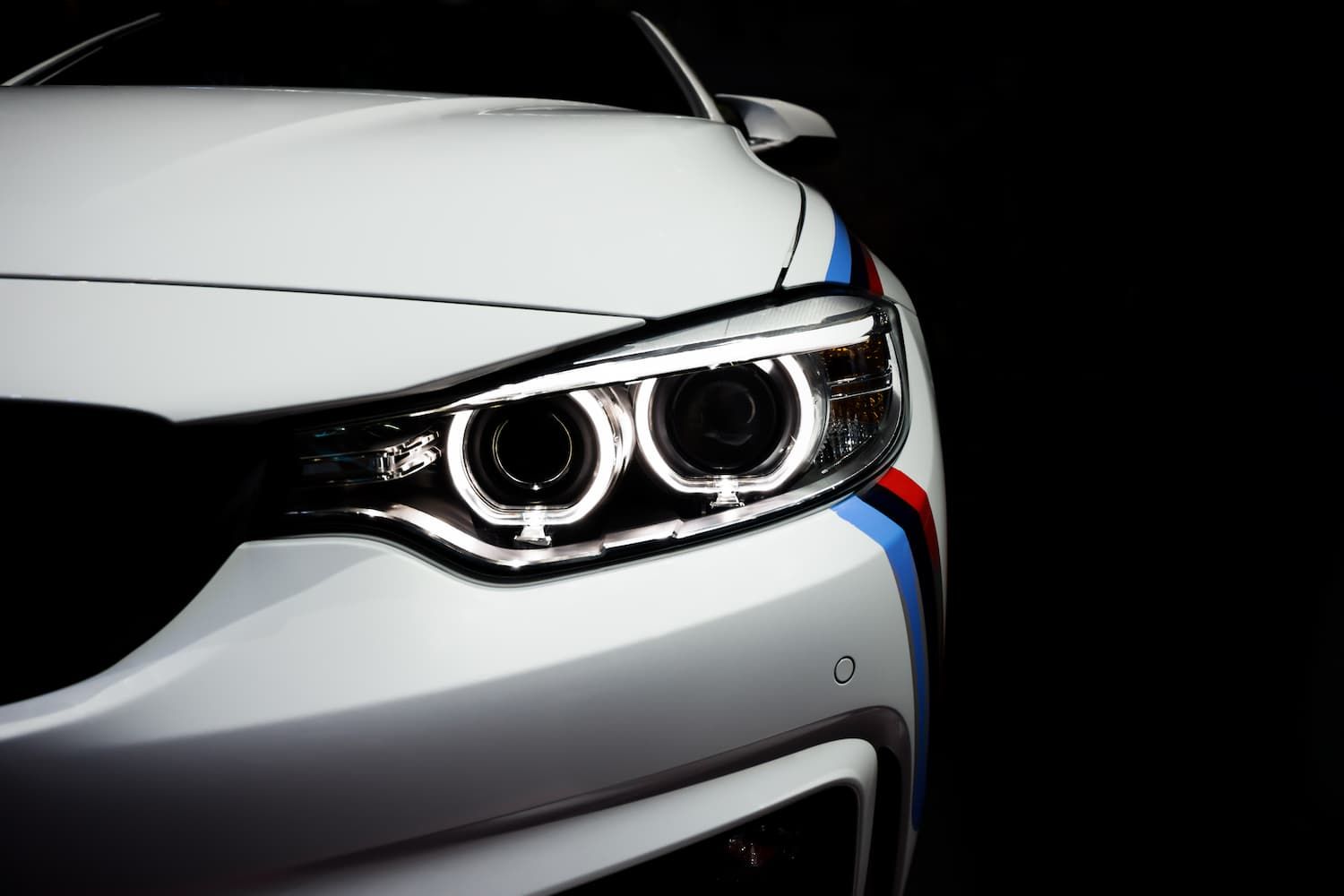 A Close Up of a White Car's Headlights on a Black Background β Jim Wall Automotive in Mittagong, NSW