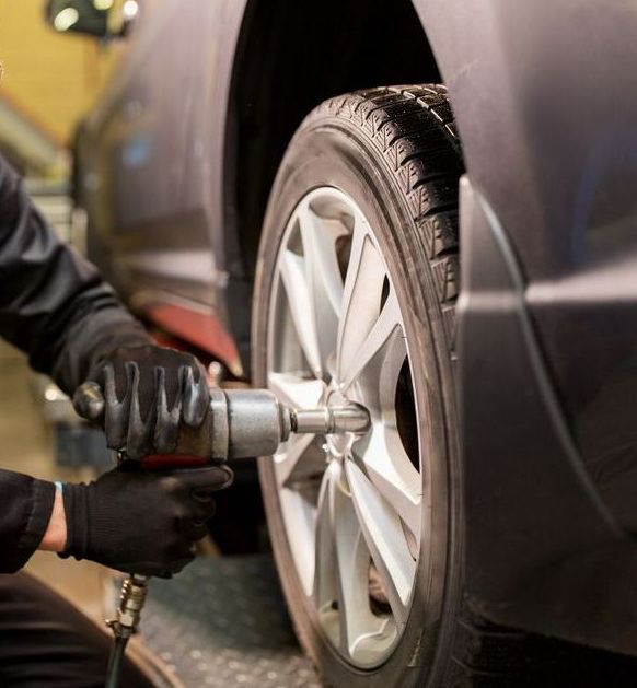 A Man is Repairing a Tyre — Jim Wall Automotive in Mittagong, NSW