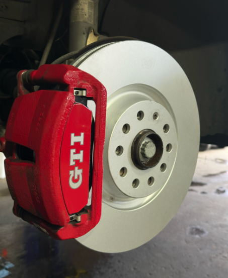 A Red GTI Brake Caliper on a White Wheel — Jim Wall Automotive in Bowral, NSW