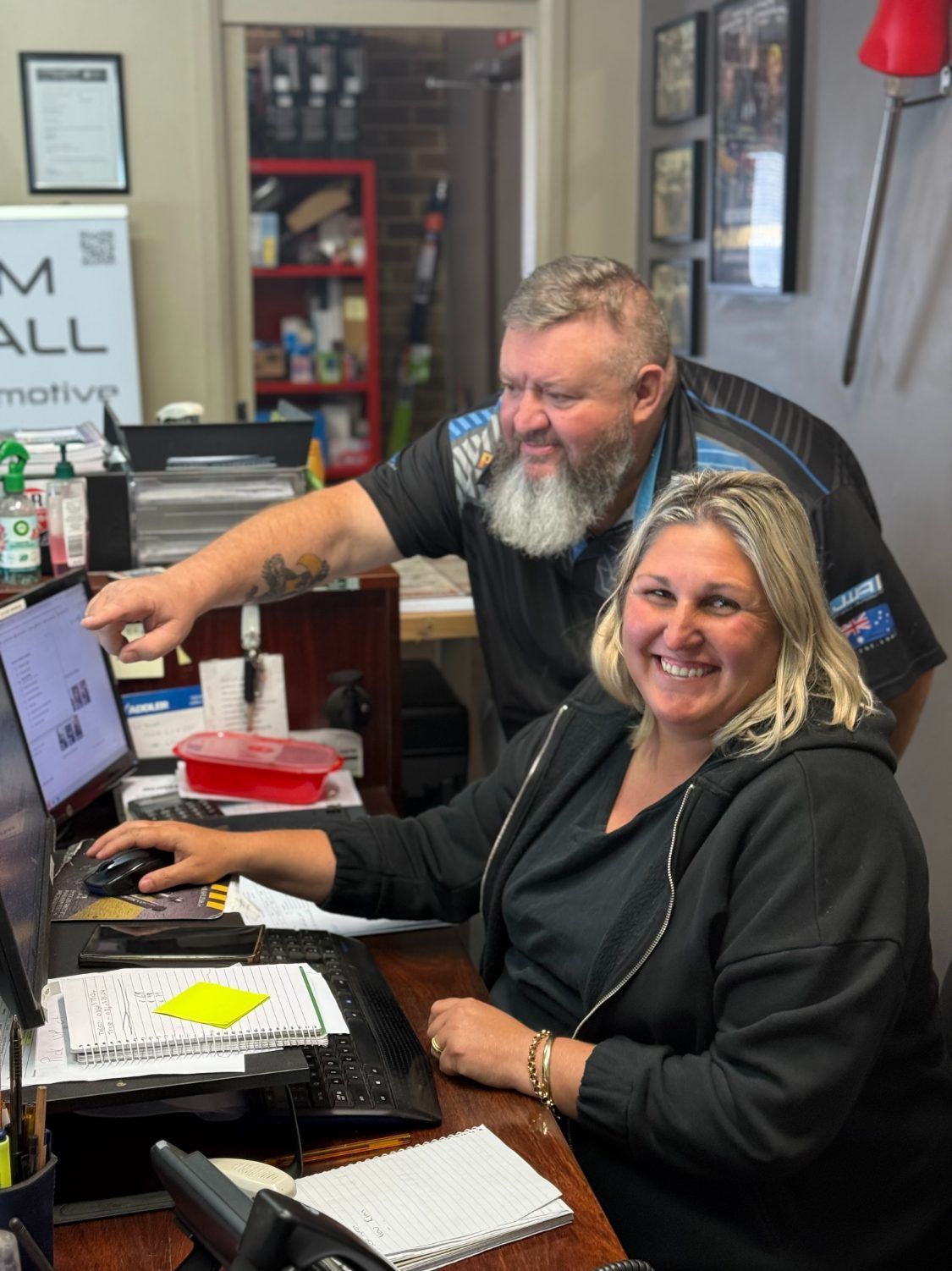 A Man and a Woman Are Sitting at a Desk in Front of a Computer β Jim Wall Automotive in Mittagong, NSW