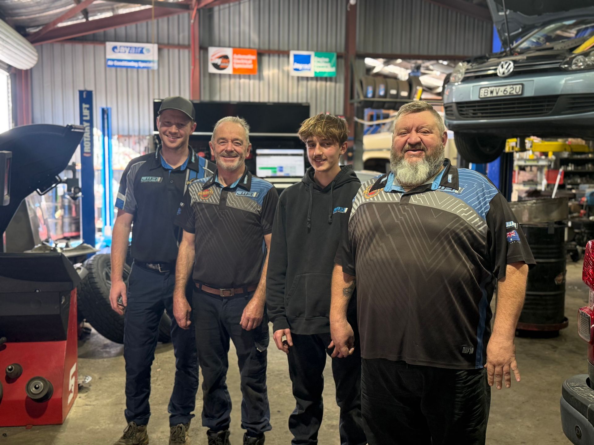 A mechanic team are standing posing for a photo β Jim Wall Automotive in Mittagong, NSW