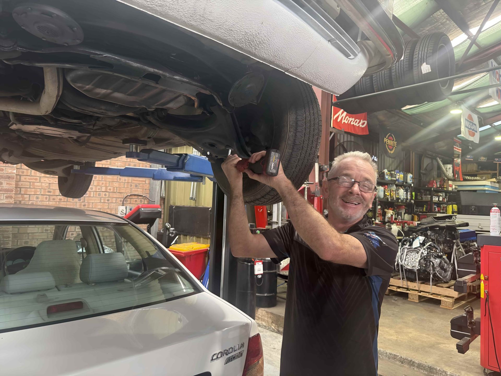 A Man is Working on the Underside of a Car in a Garage β Jim Wall Automotive in Mittagong, NSW
