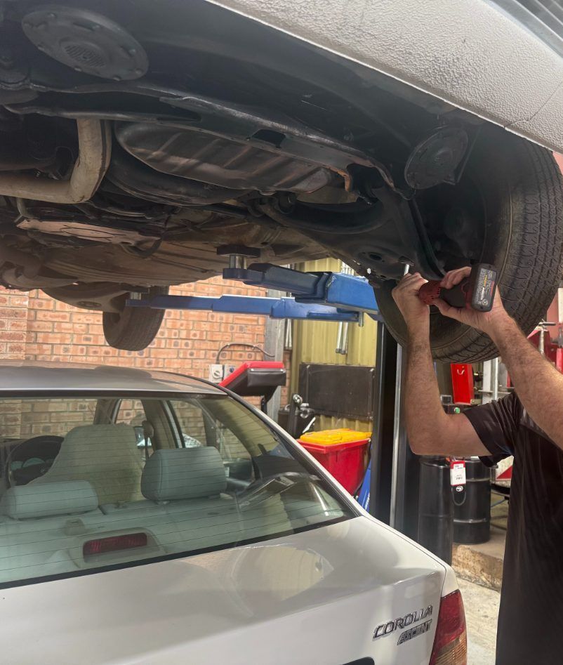 A Man is Working in the Brake and Clutch of a Car — Jim Wall Automotive in Mittagong, NSW