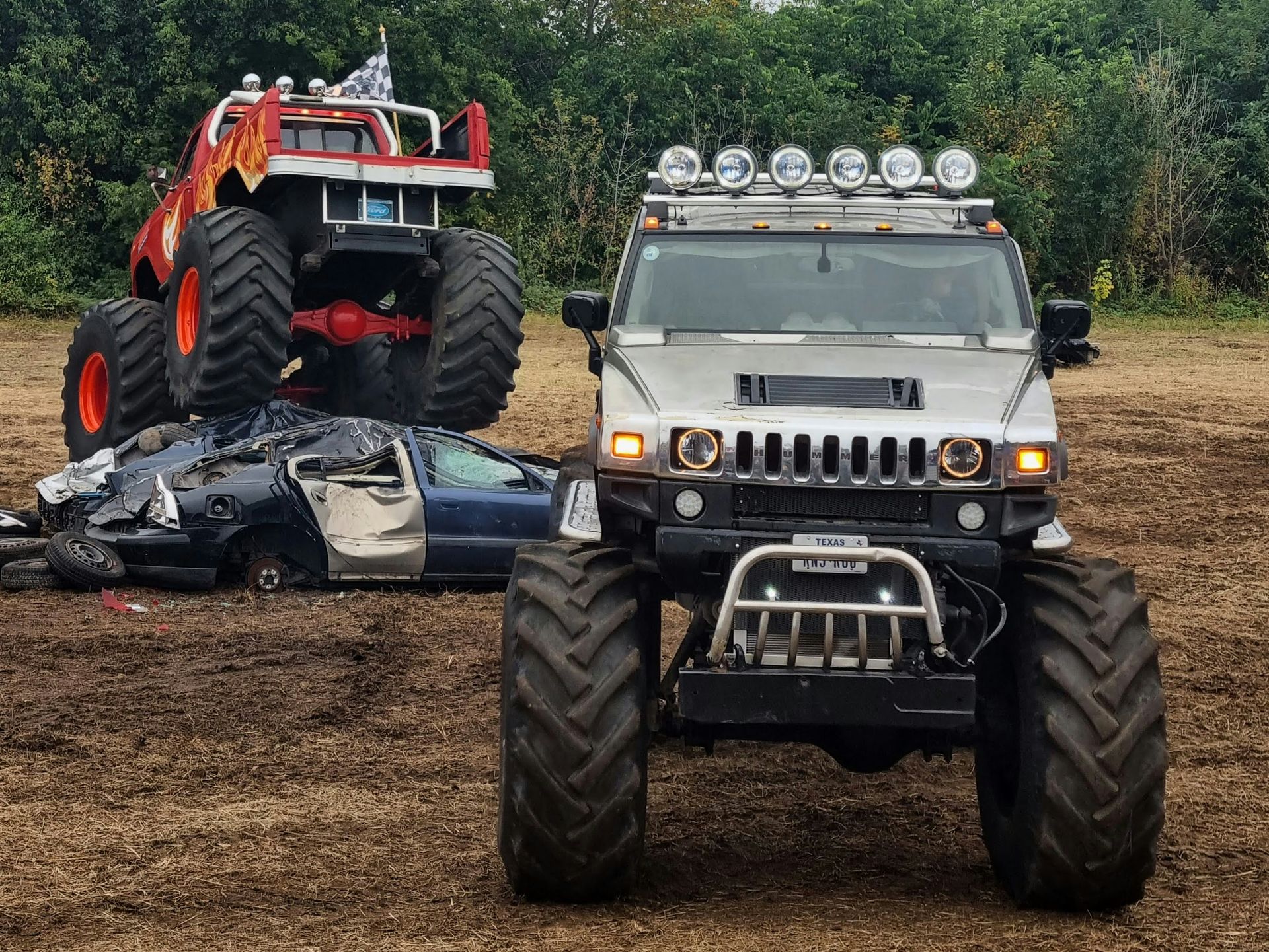 Monster trucks performing stunts and crushing cars at the Monster Truck Throwdown