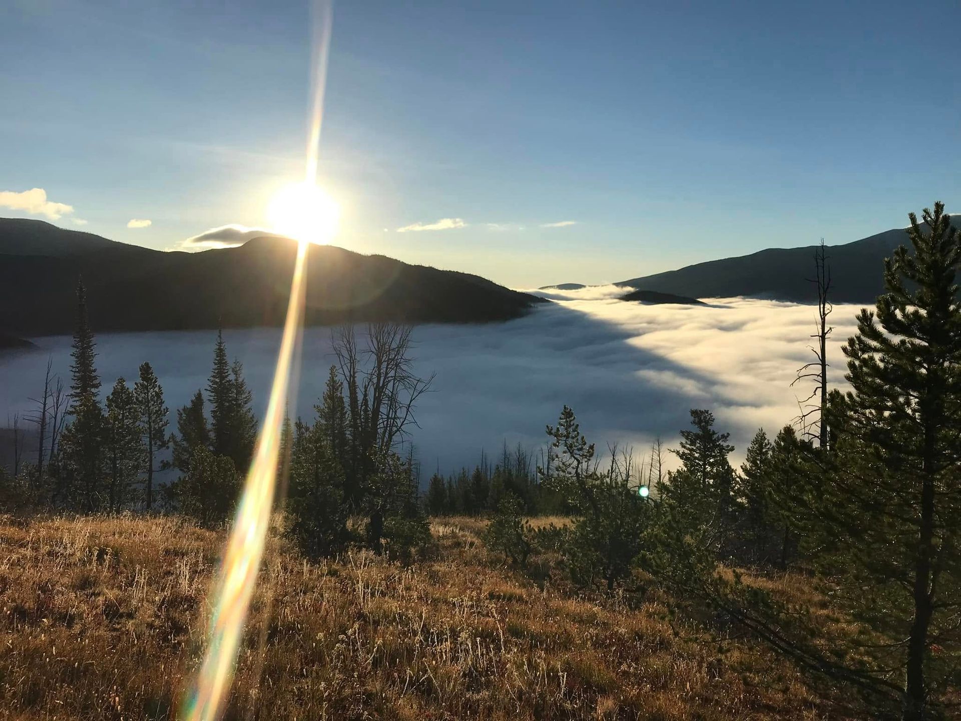 The sun is shining through the clouds in the mountains